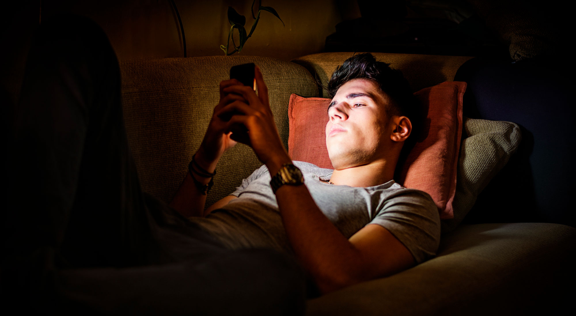 teenage male on phone at night
